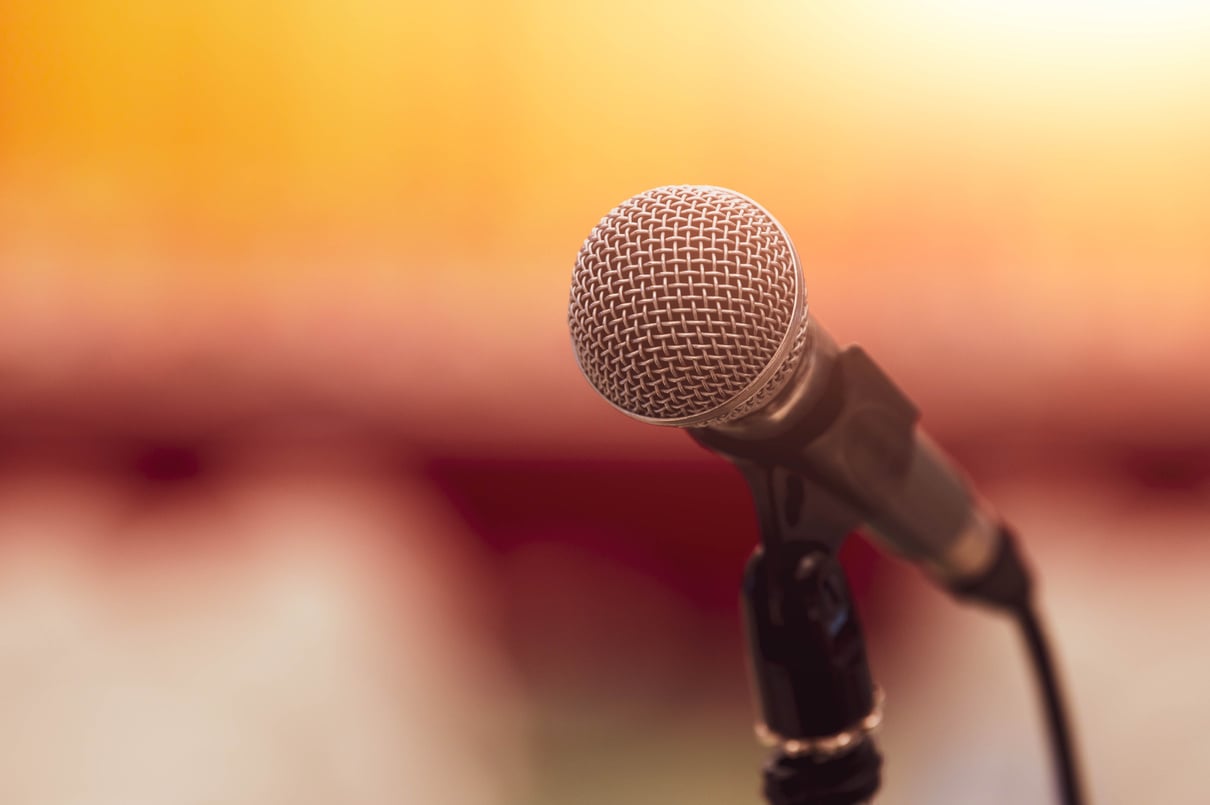 Closeup of microphone on abstract blurred background speech